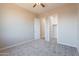 This bright bedroom features neutral carpet, a ceiling fan and a walk-in closet at 34865 N Palm Dr, San Tan Valley, AZ 85140