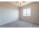 Cozy bedroom with neutral carpet, ceiling fan and a view out of the bright window at 34865 N Palm Dr, San Tan Valley, AZ 85140