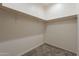 A walk-in closet features carpeted floors and a wooden hanging rod with white supports at 34865 N Palm Dr, San Tan Valley, AZ 85140
