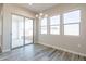 The dining area has three large windows, sliding glass doors, and wood-look tile floors at 34865 N Palm Dr, San Tan Valley, AZ 85140