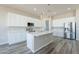 Beautiful kitchen featuring white cabinets, stainless steel appliances, and an island with pendant lighting at 34865 N Palm Dr, San Tan Valley, AZ 85140