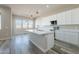 Stylish kitchen featuring white cabinets, stainless steel appliances, a large island, and wood look floors at 34865 N Palm Dr, San Tan Valley, AZ 85140