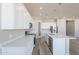 Modern kitchen with white cabinets, a quartz countertop island, and stainless steel appliances at 34865 N Palm Dr, San Tan Valley, AZ 85140