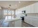 Bright kitchen features an island, stainless steel appliances, solid countertops, and ample cabinet space at 34865 N Palm Dr, San Tan Valley, AZ 85140