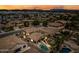 Stunning aerial view of a home with a private pool, spa, and backyard, set against a colorful sunset sky at 3671 E Kingbird Pl, Chandler, AZ 85286