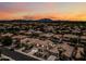 Expansive aerial view showcases a neighborhood with cozy homes, mature trees, and colorful sunset at 3671 E Kingbird Pl, Chandler, AZ 85286