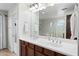 Bathroom offers dual sinks, dark wood cabinets, and a large mirror for a luxurious experience at 3671 E Kingbird Pl, Chandler, AZ 85286