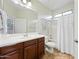 Well-lit bathroom with dark wood vanity, tile floors, and a shower-tub combination at 3671 E Kingbird Pl, Chandler, AZ 85286