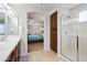Bright bathroom featuring a tub, glass shower, double sink, and a bedroom view through an archway at 3671 E Kingbird Pl, Chandler, AZ 85286