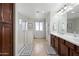 Bathroom featuring a soaking tub, glass enclosed shower, and dark wood cabinets for a modern look at 3671 E Kingbird Pl, Chandler, AZ 85286
