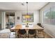 Well-lit dining area features a rustic wood table, black chairs, and sliding doors to the outdoor patio at 3671 E Kingbird Pl, Chandler, AZ 85286