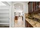 Kitchen nook with granite counter and custom cabinets that leads to dining room at 3671 E Kingbird Pl, Chandler, AZ 85286