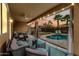 Cozy covered patio features comfortable seating, a ceiling fan, string lights, and a view of the pool at 3671 E Kingbird Pl, Chandler, AZ 85286
