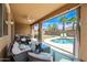 Relaxing covered patio features comfortable seating, a ceiling fan, and a view of the backyard pool at 3671 E Kingbird Pl, Chandler, AZ 85286