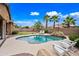 Inviting backyard pool features a rock waterfall, palm trees and comfortable lounge chairs at 3671 E Kingbird Pl, Chandler, AZ 85286