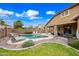 Private backyard oasis with a sparkling pool, a rock waterfall feature and lounge area at 3671 E Kingbird Pl, Chandler, AZ 85286