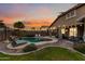 The backyard has a refreshing pool with rock waterfall, grassy areas and covered patio at 3671 E Kingbird Pl, Chandler, AZ 85286