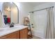 Bright bathroom featuring a vanity with solid surface countertop, and a shower over tub with a neutral shower curtain at 45475 W Guilder Ave, Maricopa, AZ 85139
