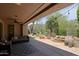 Covered patio with outdoor seating area and view of backyard featuring pond and water feature at 6714 E Amber Sun Dr, Scottsdale, AZ 85266