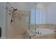 Bathroom includes a frameless glass shower, tiled walls, and a soaking tub under a window at 6714 E Amber Sun Dr, Scottsdale, AZ 85266