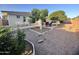 Expansive backyard with mature trees, patio seating, and stone landscaping, creating a relaxing outdoor space at 8025 E Medina Ave, Mesa, AZ 85209