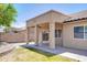 A covered patio with stone flooring leads to a grassy backyard, enclosed by a block wall for privacy at 902 W Saragosa St, Chandler, AZ 85225