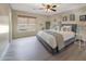 Comfortable bedroom featuring a ceiling fan, neutral tones, and a large window at 9423 W Monte Vista Rd, Phoenix, AZ 85037