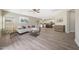 Open-concept living space featuring wood floors, a cozy white couch, and a view into the kitchen at 9423 W Monte Vista Rd, Phoenix, AZ 85037