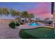 Lush backyard showcasing a sparkling pool, putting green, and well-manicured landscaping, perfect for recreation and leisure at 1019 N Tambor Cir, Mesa, AZ 85207