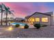 Beautiful backyard featuring a sparkling pool, mature landscaping, and outdoor lighting, perfect for evening relaxation and entertaining at 1019 N Tambor Cir, Mesa, AZ 85207