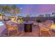 Backyard patio with rocking chairs, a fire pit, desert landscaping, and privacy walls at 1019 N Tambor Cir, Mesa, AZ 85207