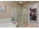 Bathroom with large glass shower, soaking tub and access to walk-in closet at 1019 N Tambor Cir, Mesa, AZ 85207