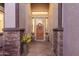Inviting entryway with stone accents, decorative columns, and a beautiful wooden front door at 1019 N Tambor Cir, Mesa, AZ 85207