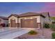 Attractive exterior view featuring a two-car garage with decorative stone accents and well-maintained desert landscaping at 1019 N Tambor Cir, Mesa, AZ 85207