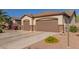 Attached two-car garage featuring brown doors with decorative stone accents, complementing the home's exterior at 1019 N Tambor Cir, Mesa, AZ 85207