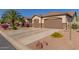 Spacious driveway leading to a two-car attached garage, adorned with decorative stone accents, surrounded by desert landscaping at 1019 N Tambor Cir, Mesa, AZ 85207