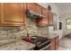 Close-up of the kitchen featuring granite countertops, stylish backsplash, and modern appliances at 1019 N Tambor Cir, Mesa, AZ 85207
