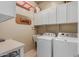 Functional laundry room with washer, dryer, white cabinetry and a sink at 1019 N Tambor Cir, Mesa, AZ 85207