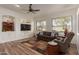 Cozy living room with wood floors, large windows, and a comfortable seating arrangement for relaxation at 1019 N Tambor Cir, Mesa, AZ 85207
