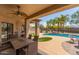 Inviting covered outdoor living space with dining, putting green, and sparkling pool at 1019 N Tambor Cir, Mesa, AZ 85207