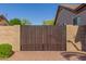 Wooden side gate with brick pillars, offering privacy and access to the property's backyard area at 1019 N Tambor Cir, Mesa, AZ 85207