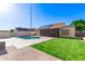 Well-maintained backyard features a pool, green lawn, and a screened-in porch at 1207 E Sequoia Dr, Phoenix, AZ 85024