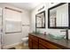 Well-lit bathroom featuring double sinks, decorative mirrors, and a large window at 1207 E Sequoia Dr, Phoenix, AZ 85024