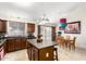 Open kitchen boasts ample cabinet space, center island with seating, and adjacent dining area overlooking the pool at 1207 E Sequoia Dr, Phoenix, AZ 85024