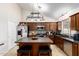 Well lit kitchen with an island, dark countertops, stainless steel appliances, and dark cabinets at 1207 E Sequoia Dr, Phoenix, AZ 85024