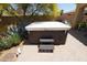 Relaxing backyard featuring a covered hot tub and mature trees offering plenty of shade on a sunny day at 18436 W Shasta St, Goodyear, AZ 85338