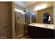 Bathroom featuring double sinks, vanity and glass shower with tile flooring and natural light at 18436 W Shasta St, Goodyear, AZ 85338