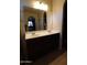 Bathroom featuring double sinks, vanity with tile flooring and a mirror reflecting the bedroom at 18436 W Shasta St, Goodyear, AZ 85338