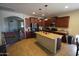Open kitchen with an island, granite countertops, stainless appliances, and dark wood cabinets at 18436 W Shasta St, Goodyear, AZ 85338