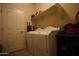 Functional laundry room with modern appliances and convenient storage shelving at 18436 W Shasta St, Goodyear, AZ 85338